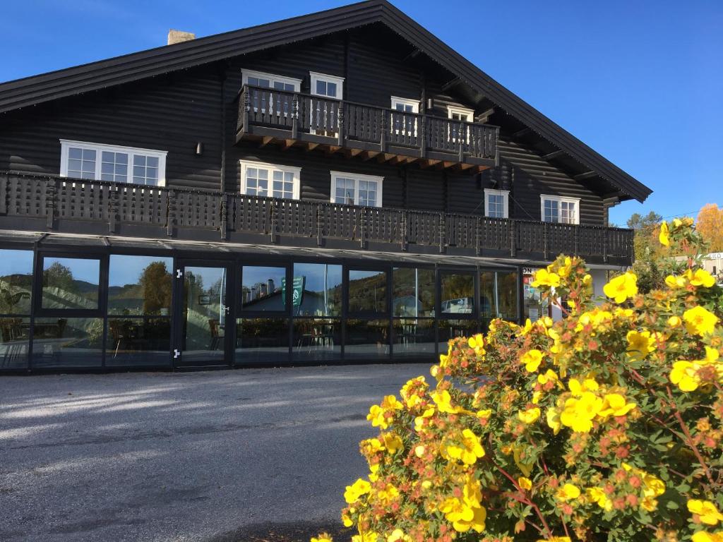 Un grand bâtiment avec des fenêtres et un balcon est disponible. dans l'établissement Øen Turistsenter Apartments, à Geilo
