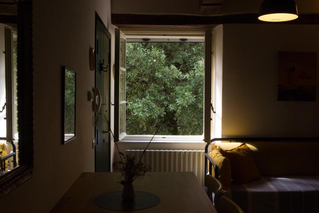 um quarto com uma janela, uma mesa e um sofá em La finestra sul parco em Lucca