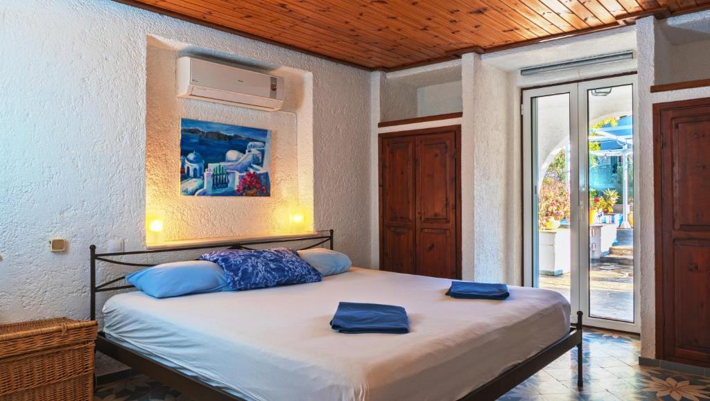 Un dormitorio con una cama con almohadas azules. en Spiti Galini, "Haus der Zufriedenheit", en Paralía Sergoúlas