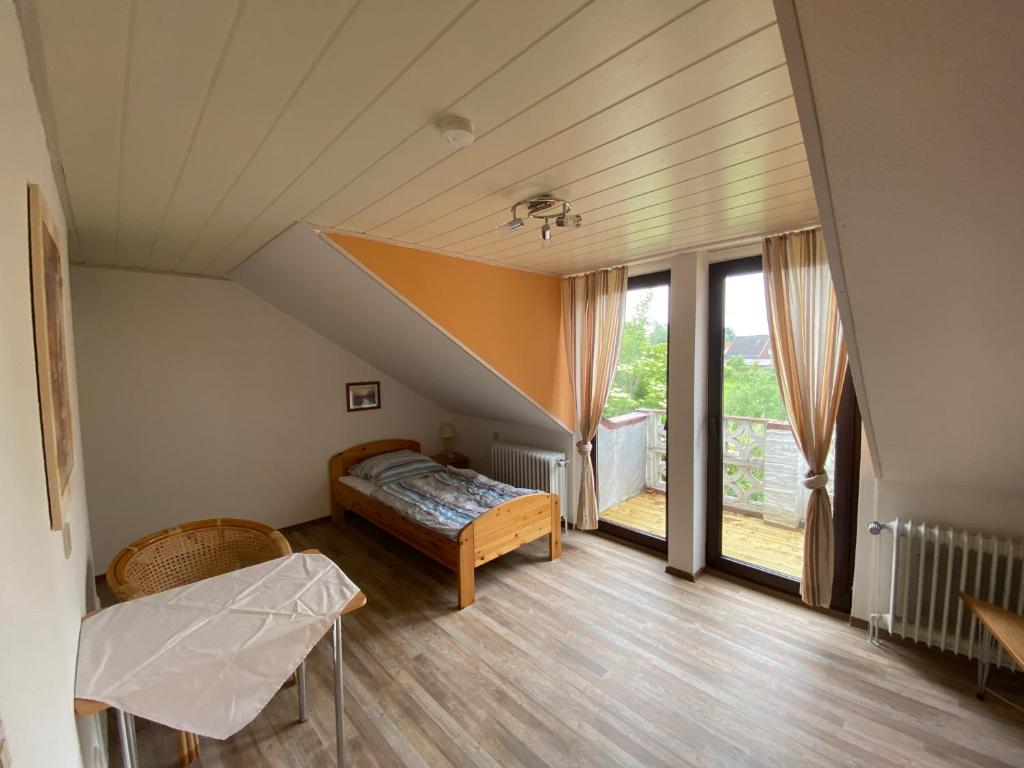 a bedroom with a bed and a large window at Pension zum Leuchtfeuer in Butjadingen