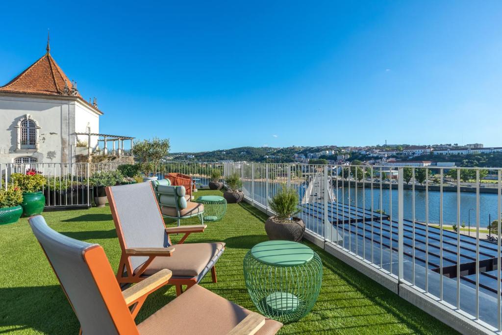 d'un balcon avec des chaises et une vue sur l'eau. dans l'établissement Hästens Sleep Experience FLH Hotels Coimbra, à Coimbra