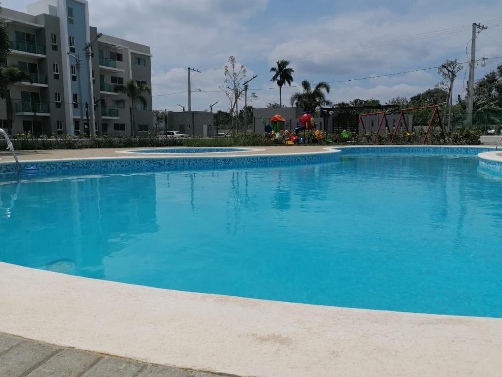 a large swimming pool with blue water at My BREEZES SPACE AC, POOL, 3 HAB, SANTIAGO in Santiago de los Caballeros