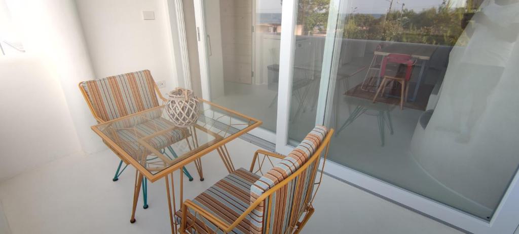 a room with two chairs and a table on a balcony at Casa Mediterranea Jacuzzi riscaldata con Caminetto in Specchiolla