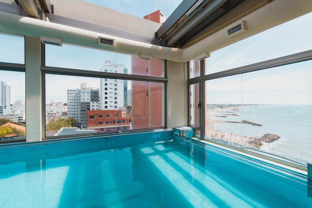 a swimming pool with a view of the ocean at SEC Hotel in Mar del Plata