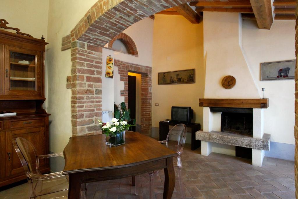 a living room with a table and a fireplace at La Locanda del Vino Nobile in Sant'Albino