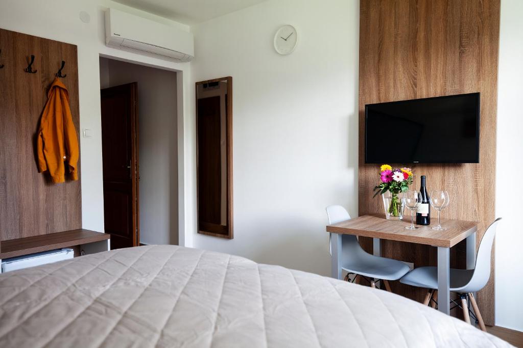 a bedroom with a bed and a desk with a television at HVT Comfort Apartments in Mezőkövesd