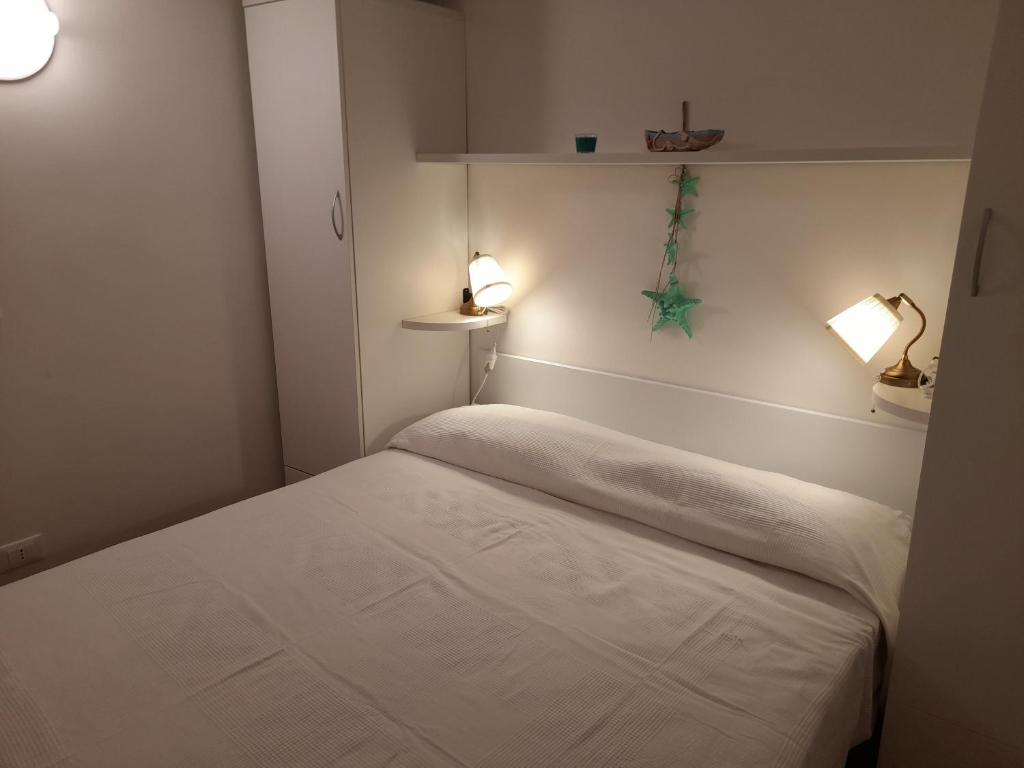 a small room with a bed and two lamps at La soffitta vicino al mare in Varazze