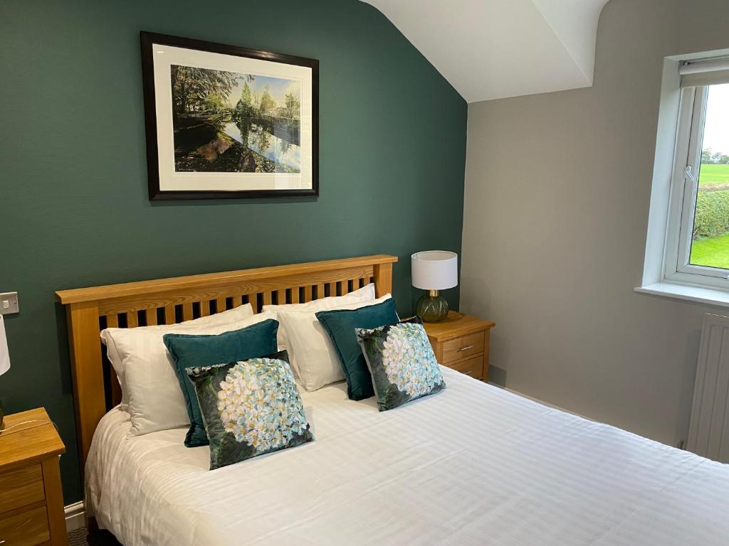 um quarto com uma cama branca com almofadas em Rufford Arms Hotel em Rufford