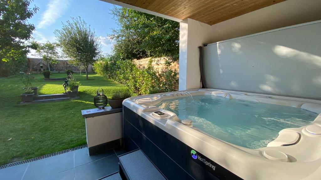 a hot tub on a patio with a view of a yard at B&B Le Jardin de Sophie in Geraardsbergen