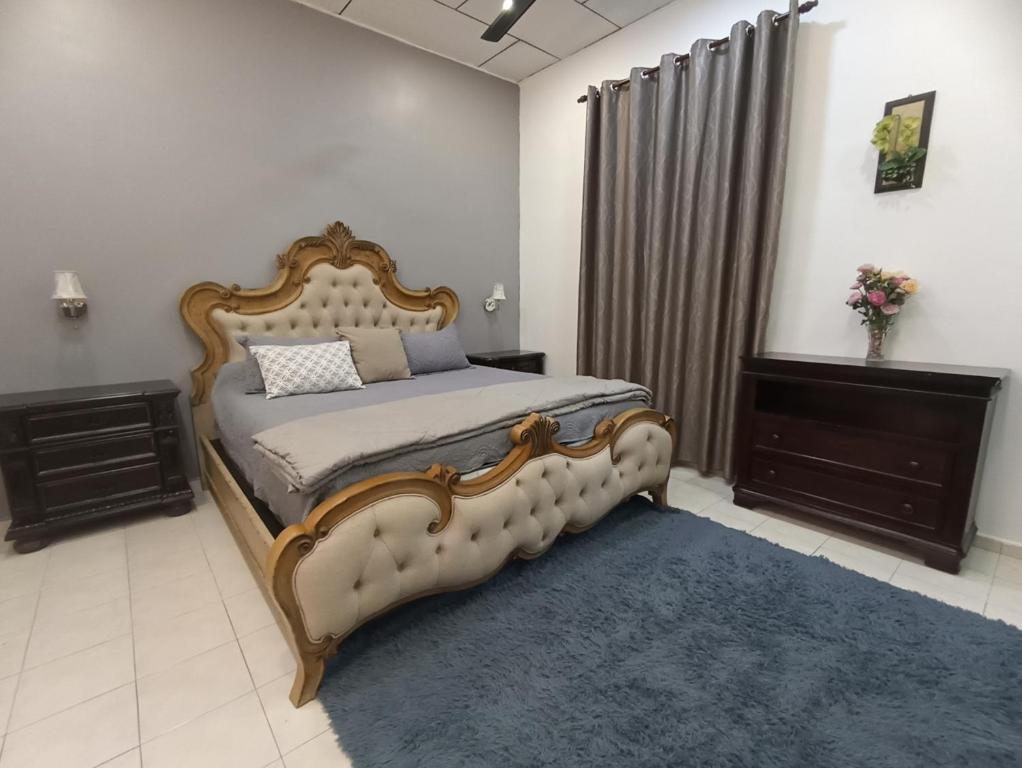 a bedroom with a large bed and a blue rug at Basrie Villa Pagoh - Mini Cinema , Private Pool , Wi-Fi , NetFlix in Muar