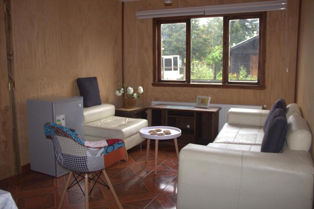 a living room with white furniture and a window at El Refugio de la Cuenca in Puerto Clocker