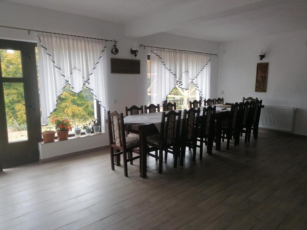 un comedor con una mesa larga y sillas en Conacul Elenei, en Poiana Mărului