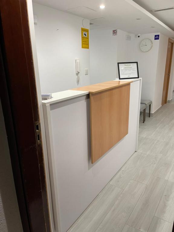 a room with a white wall and a wooden counter at Hostal Portugal in Alicante