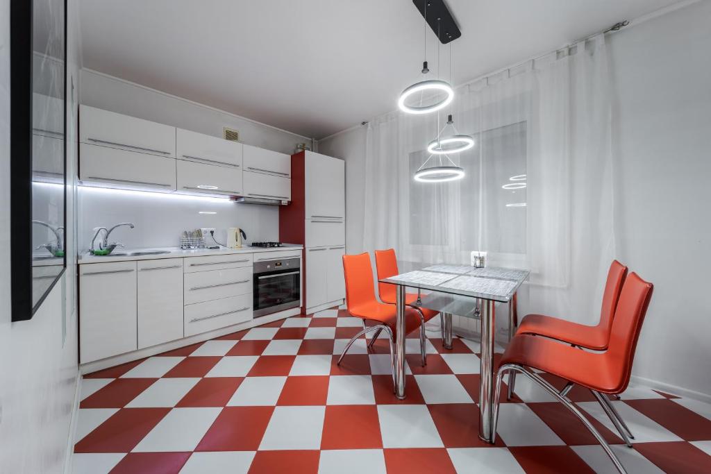 a kitchen with orange chairs and a table in it at Apartment Kiev House in Kyiv