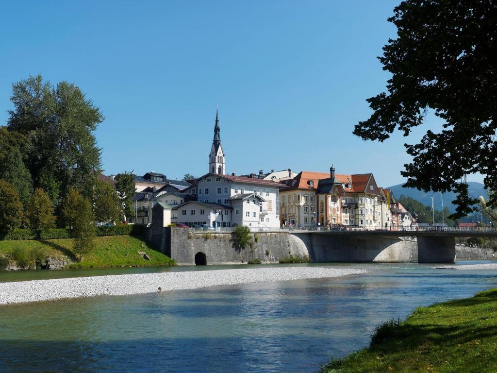 a bridge over a river with a town in the background at FeWo Waldi am Kurpark in Bad Tölz