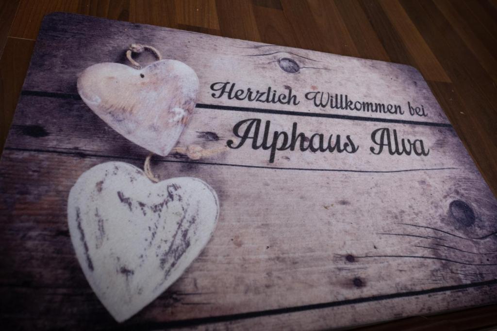 dois corações de madeira sentados em cima de uma caixa de madeira em Alprocks Alvaresort em Bichlbach