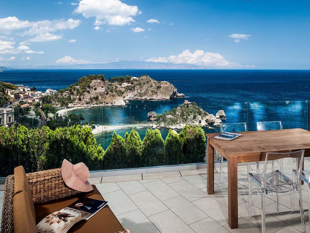 balkon ze stołem i widokiem na ocean w obiekcie Isola Bella w Taominie