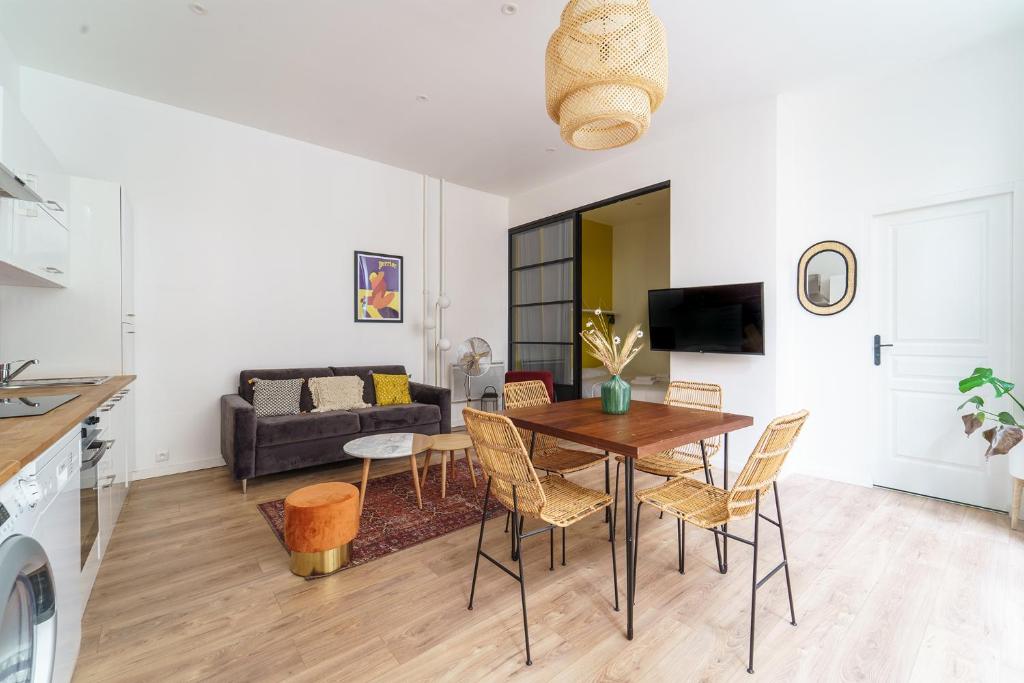 une cuisine et un salon avec une table et des chaises dans l'établissement Parisuites Central Canal Saint Martin Chic & Design & Cosy, à Paris
