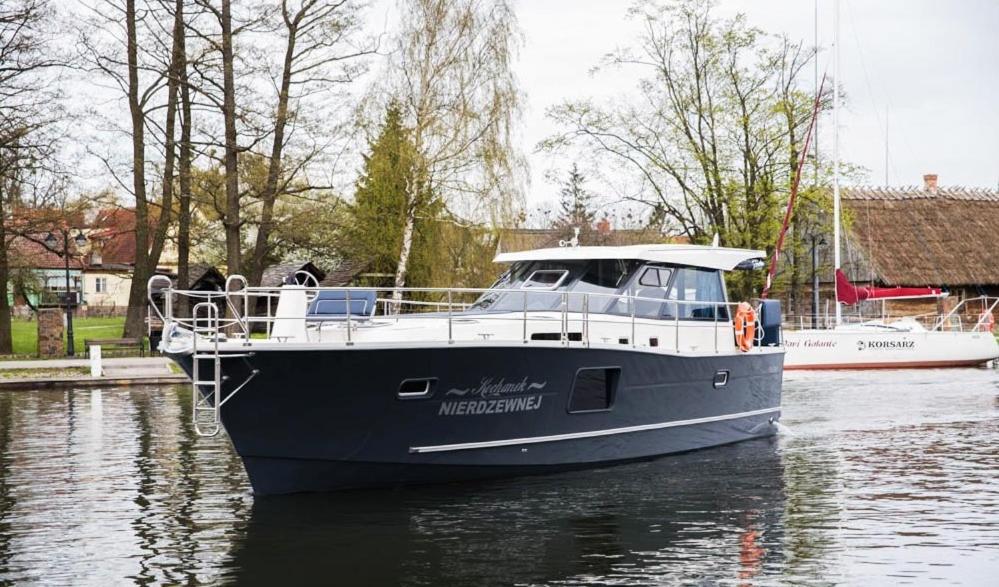 a blue boat is docked in the water at Jacht motorowy Nautika 1300 LUX in Wilkasy