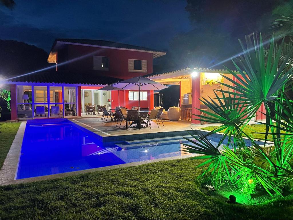 une maison avec une piscine la nuit dans l'établissement Casa Complexo Costa do Sauípe, à Costa do Sauipe
