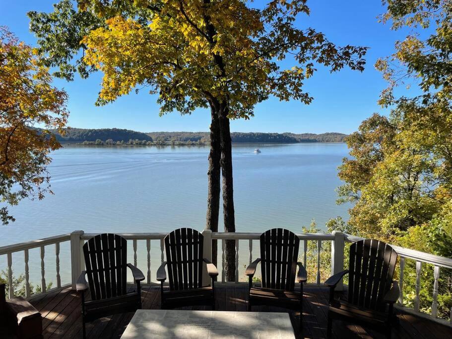 four chairs sitting on a deck with a view of a lake at Main Channel Manor in Cadiz