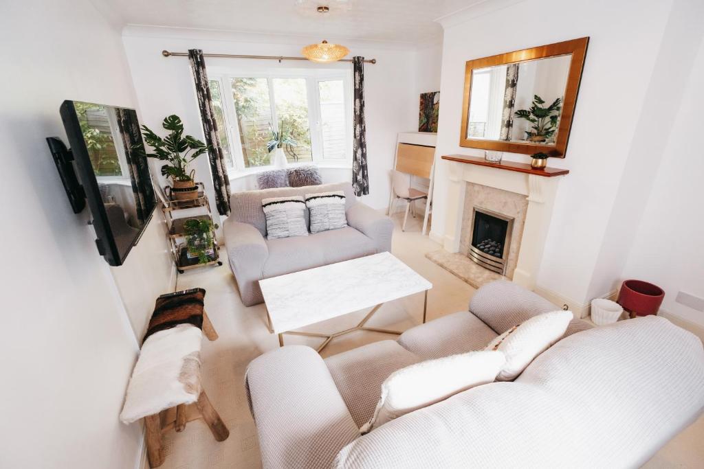 a living room with two couches and a fireplace at Booker Avenue House - 4 bedroom house with garden and parking in Milton Keynes