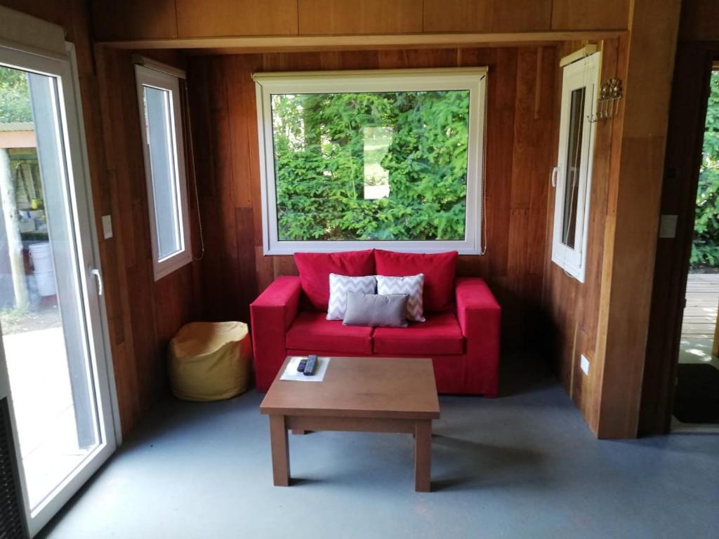 un sofá rojo en una habitación con ventana en Casa Gingins en San Martín de los Andes