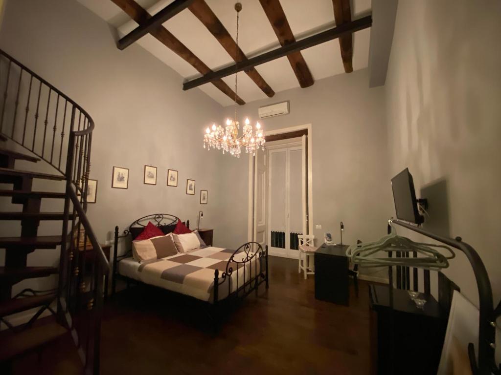 a living room with a bed and a chandelier at Anima Partenopea in Naples