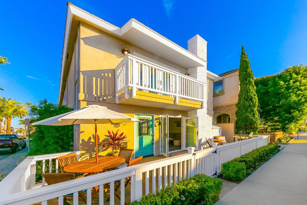 a house with a white fence and an umbrella at Balboa Island Diamond Resort Compound in Newport Beach