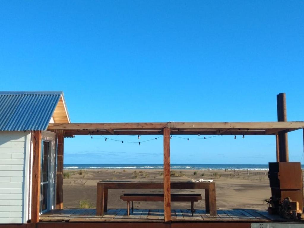 a picnic table on a deck overlooking the beach at La Luisa in Balneario Reta