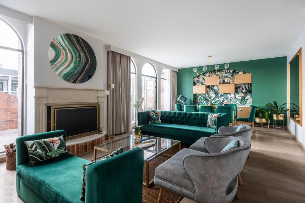 a living room with green furniture and a fireplace at Four Seasons Hotel Bogota in Bogotá