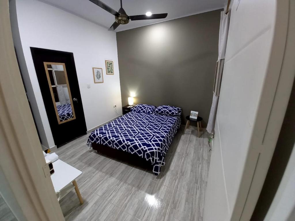 1 dormitorio con 1 cama con sábanas azules y blancas en Como en casa, en La Dorada