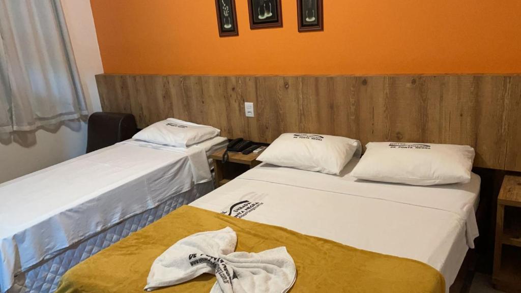 Hotel Enseada de Ponta Negra في ناتال: غرفة بسريرين عليها مناشف
