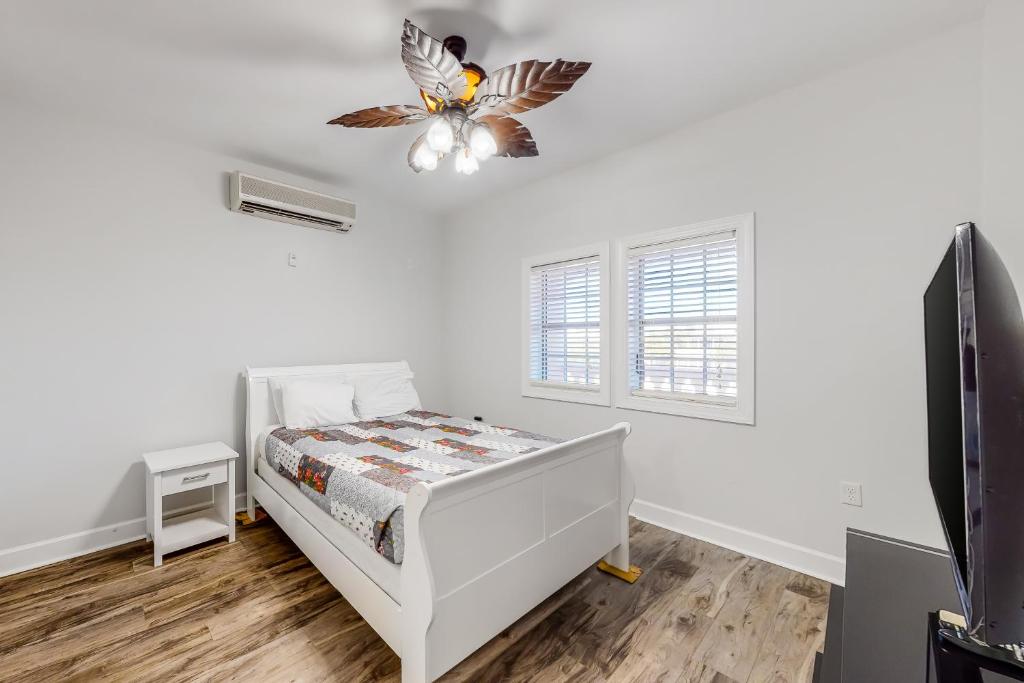 1 dormitorio blanco con 1 cama y ventilador de techo en Village of South Walton CB 243, en Rosemary Beach