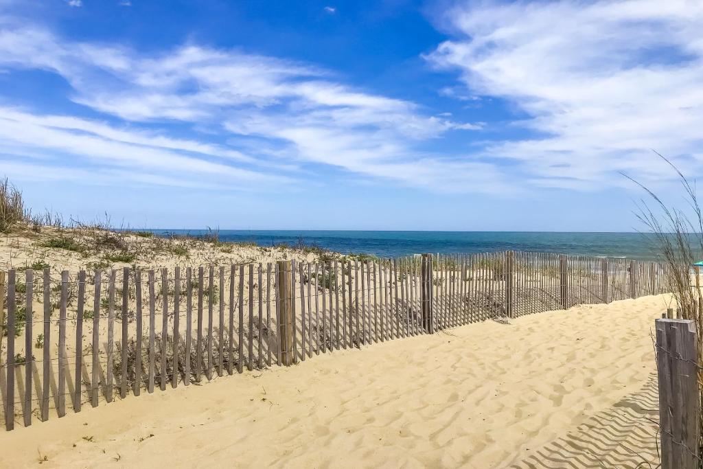 a fence on the beach with the ocean in the background at Sea Palms in Ocean City