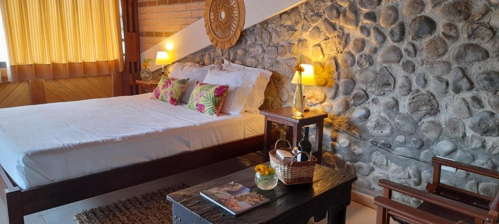 Ecohotel Bordones في Isnos: غرفة نوم بسرير وجدار حجري