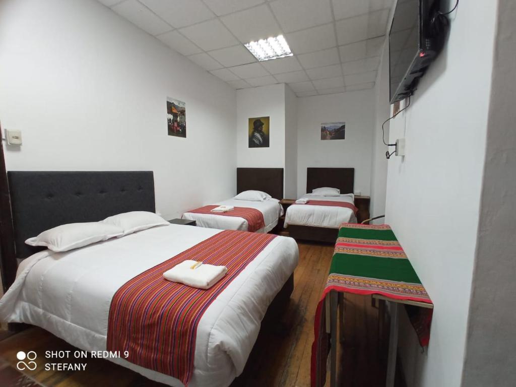 a room with three beds in a room at Catedral in Arequipa