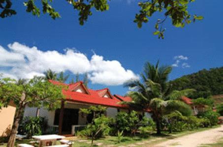 una casa con techo rojo y algunas palmeras en Lanta Bee Garden Bungalow SHA Extra Plus, en Ko Lanta