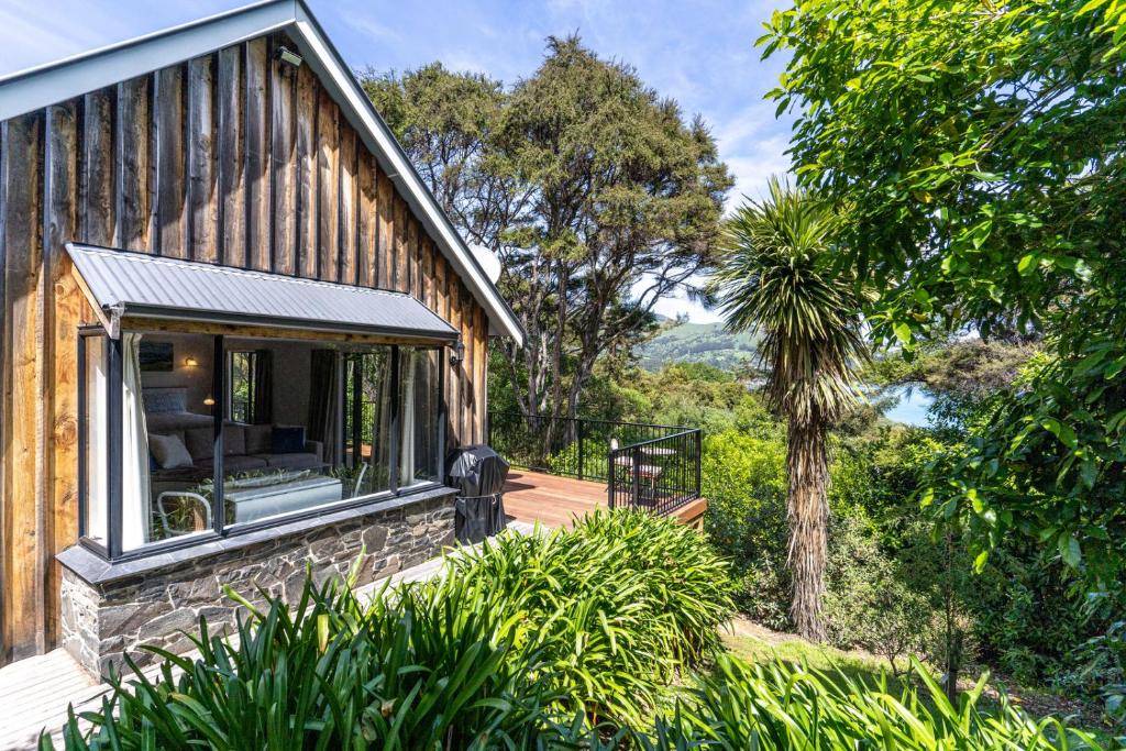 una casa con una grande finestra sul lato di Woodside - Akaroa Holiday Cottage ad Akaroa