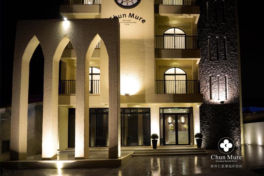 a building with a clock on the side of it at Chun Mure Hotel in Dahan