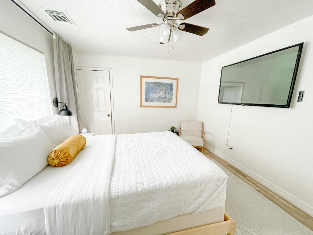 sypialnia z białym łóżkiem i wentylatorem sufitowym w obiekcie Boho Chic w mieście Humble