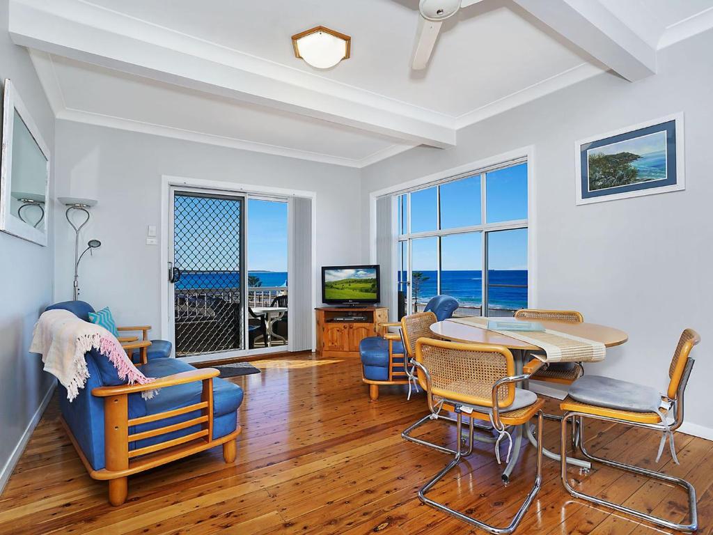 恩瑞斯的住宿－Beachcomer 1，一间带桌椅和海洋的客厅