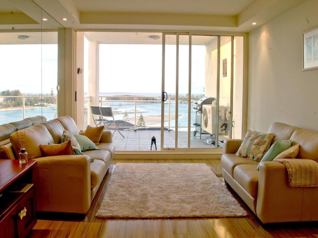a living room with two couches and a large window at Ocean Views Sundrift Unit 26 in The Entrance