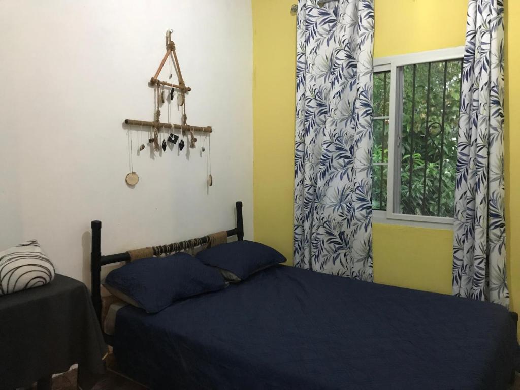 Schlafzimmer mit einem Bett und einem Fenster mit Vorhängen in der Unterkunft Soursop Hostel in Cueta