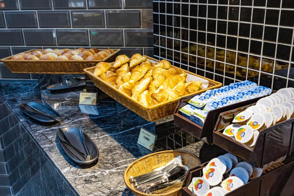 a bakery counter with baskets of pastries and bread at Kenting Long Beach Hotel in Checheng