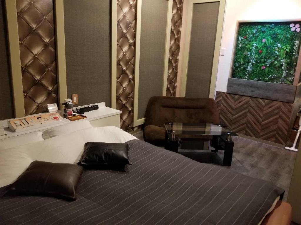 a bedroom with a bed and a desk and a window at ホテルLambie in Tōgane