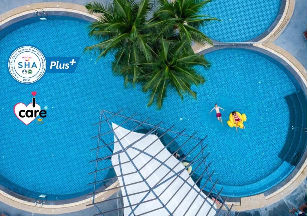 an overhead view of a swimming pool with a palm tree at R-Mar Resort and Spa - SHA Plus in Patong Beach