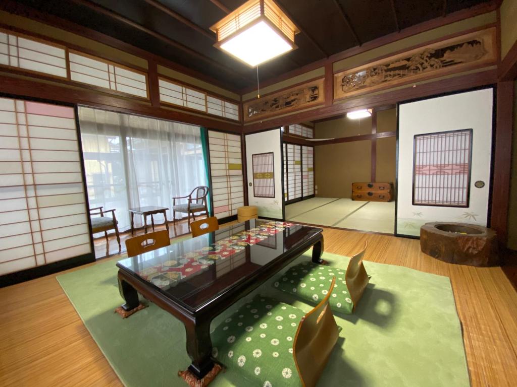 um quarto com uma mesa e cadeiras num quarto em ゲストハウス山吹 em Toyama