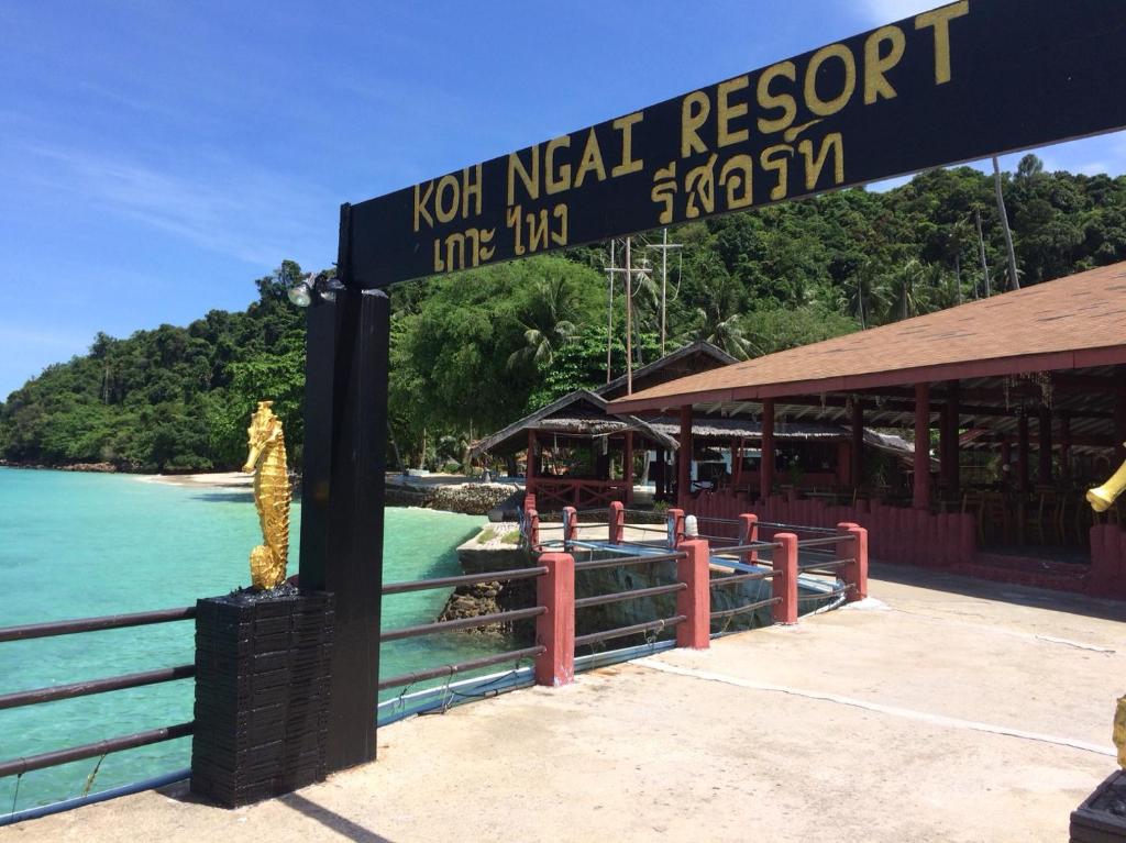 a sign for a resort next to the ocean at Koh Ngai Resort in Ko Ngai