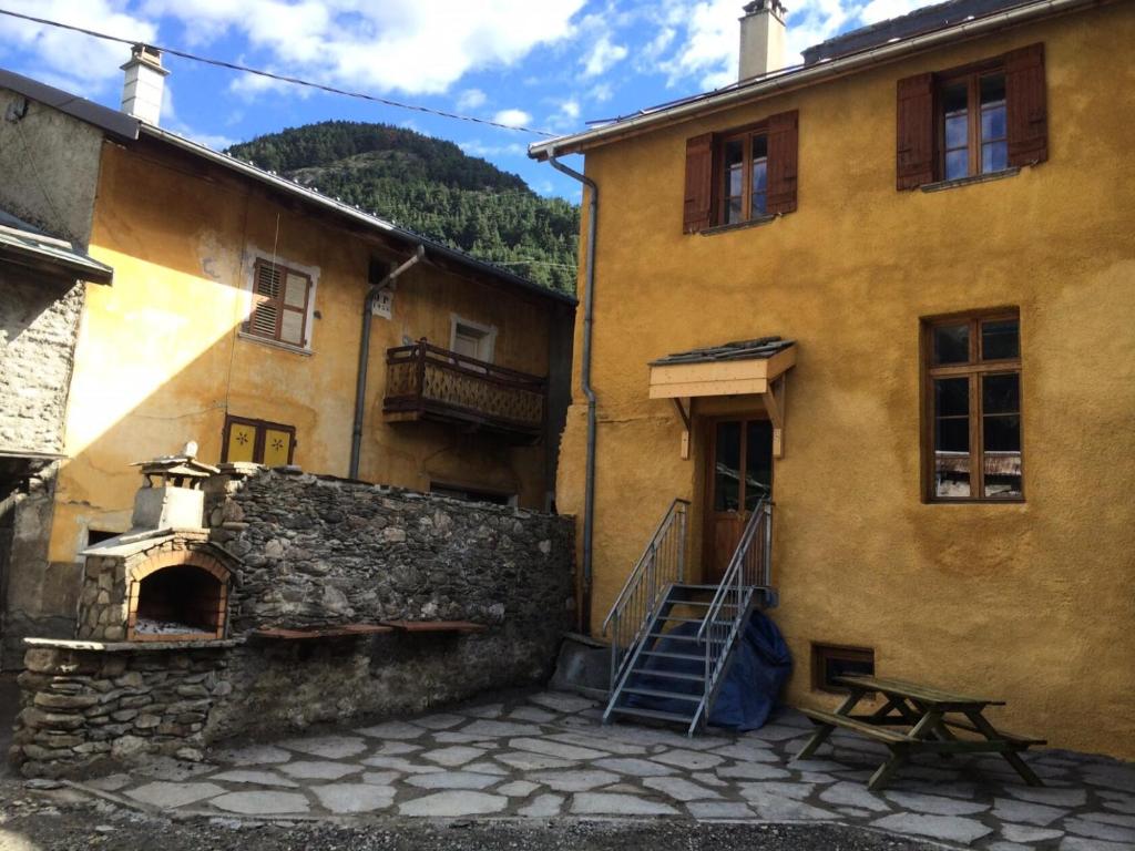 a yellow building with a staircase in front of it at Appartement 4 pièces 10 pers. en plein centre de la station 82072 in Termignon